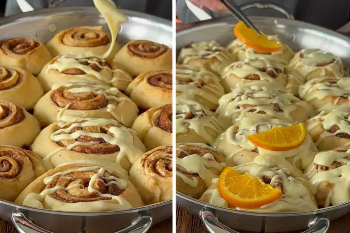 Deliciosos rollitos de canela recién horneados, cubiertos con glaseado blanco y decorados con gajos de naranja.
