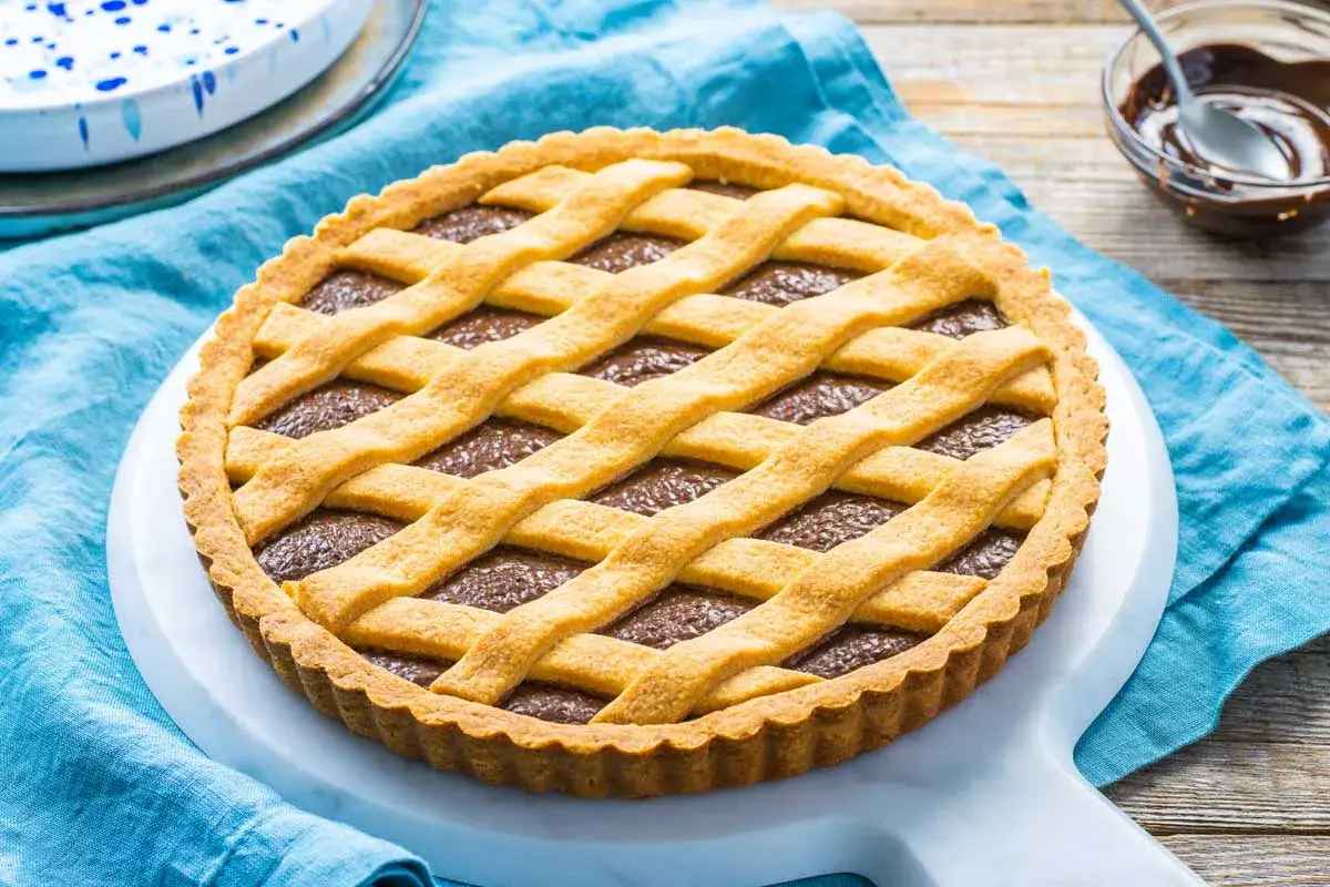 Deliziosa crostata alla nutella con una griglia dorata di pasta frolla. Perfetta per ogni occasione, un vero piacere per il palato.