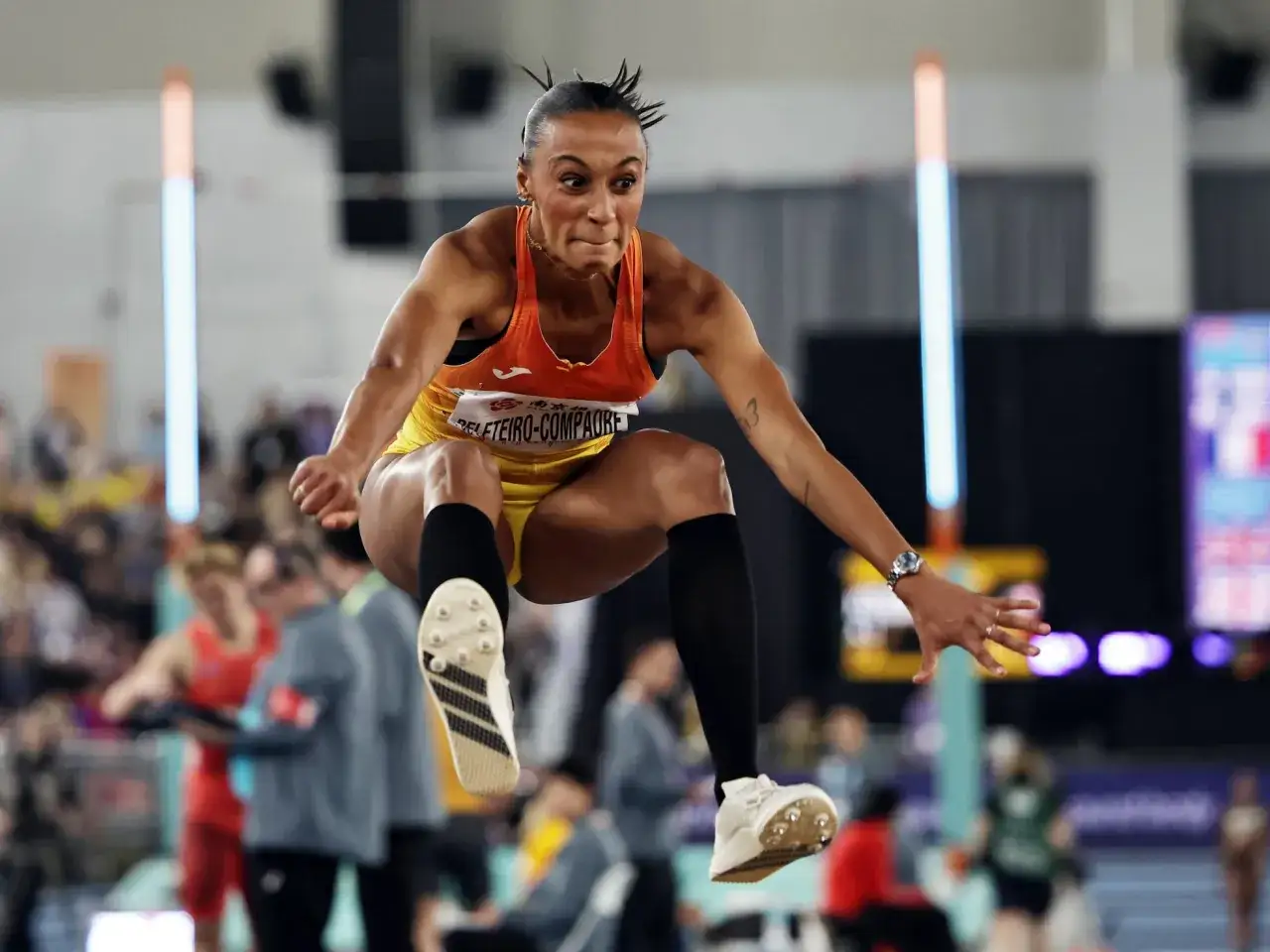 Ana Peleteiro en pleno triple salto, con la mirada fija y el cuerpo tenso, lista para aterrizar.