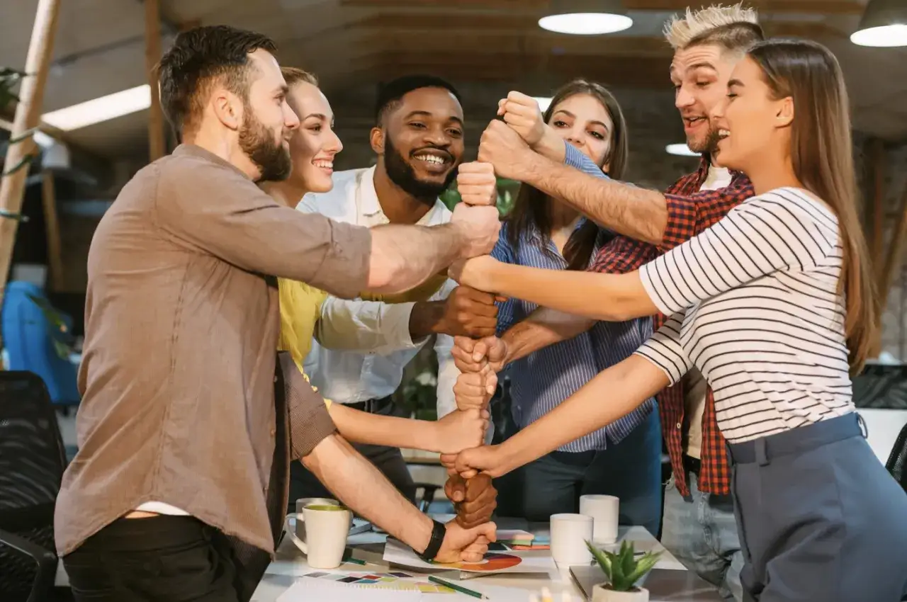 Une équipe soudée célèbre un événement d'entreprise original, unissant leurs poings pour symboliser la force collective et la réussite.