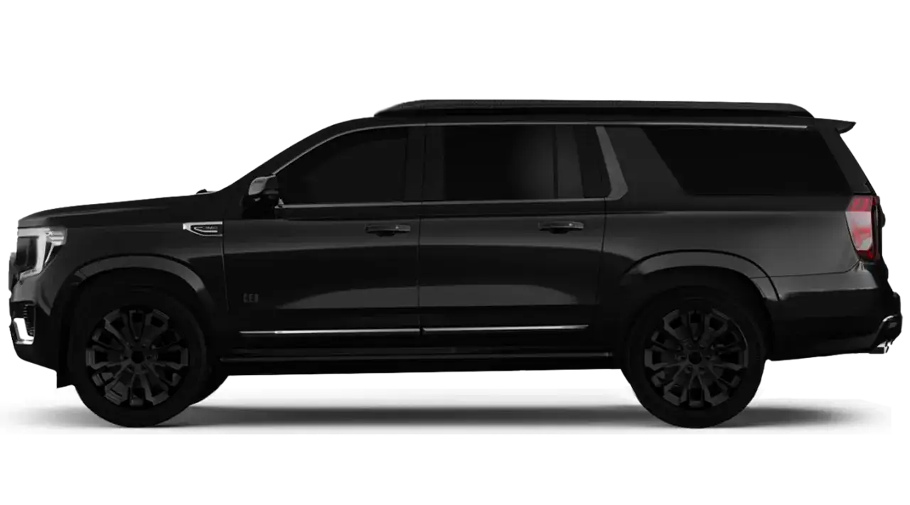 Elegancki, czarny GMC Yukon w wersji CEO, z przyciemnianymi szybami i czarnymi felgami, prezentuje się imponująco na tle czerni.