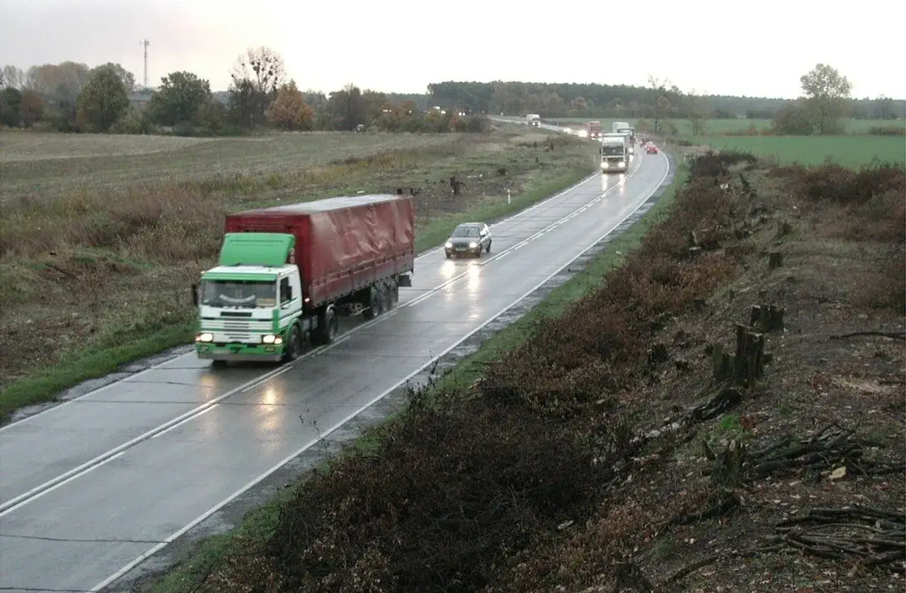 Ciężarówka i samochody jadą mokrą drogą. Czy autostrada Gliwice Wrocław jest płatna? Trudno powiedzieć, ale ruch jest spory.