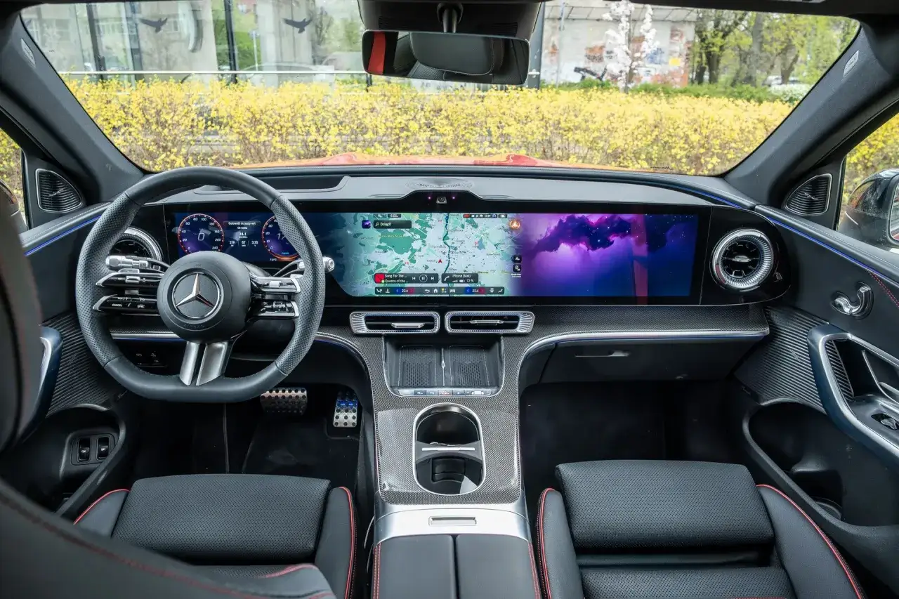 Wnętrze Mercedes EQC z dużym ekranem nawigacji i cyfrowymi zegarami.