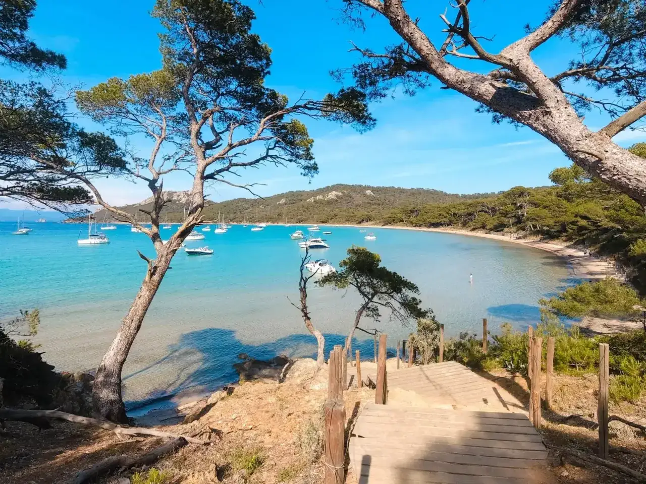 Spiaggia con acque turchesi e barche a vela, un'idea perfetta per sapere dove andare a maggio in Europa.