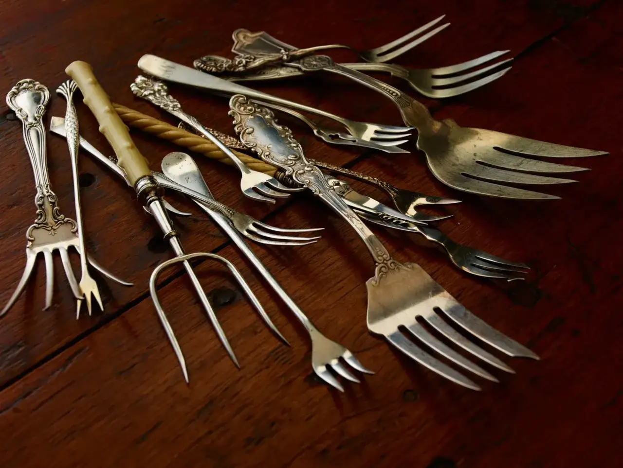 Une collection de couverts anciens, dont des fourchettes de diff&eacute;rentes tailles et styles, &eacute;voque la question : qui a invent&eacute; les couverts ?