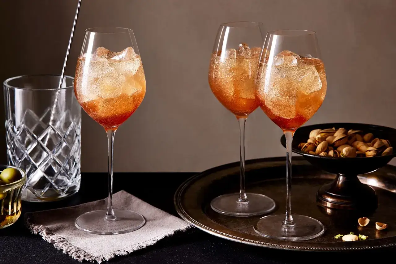 Tre Aperol Spritz, Italiens nationaldryck, serveras med is och pistagenötter.