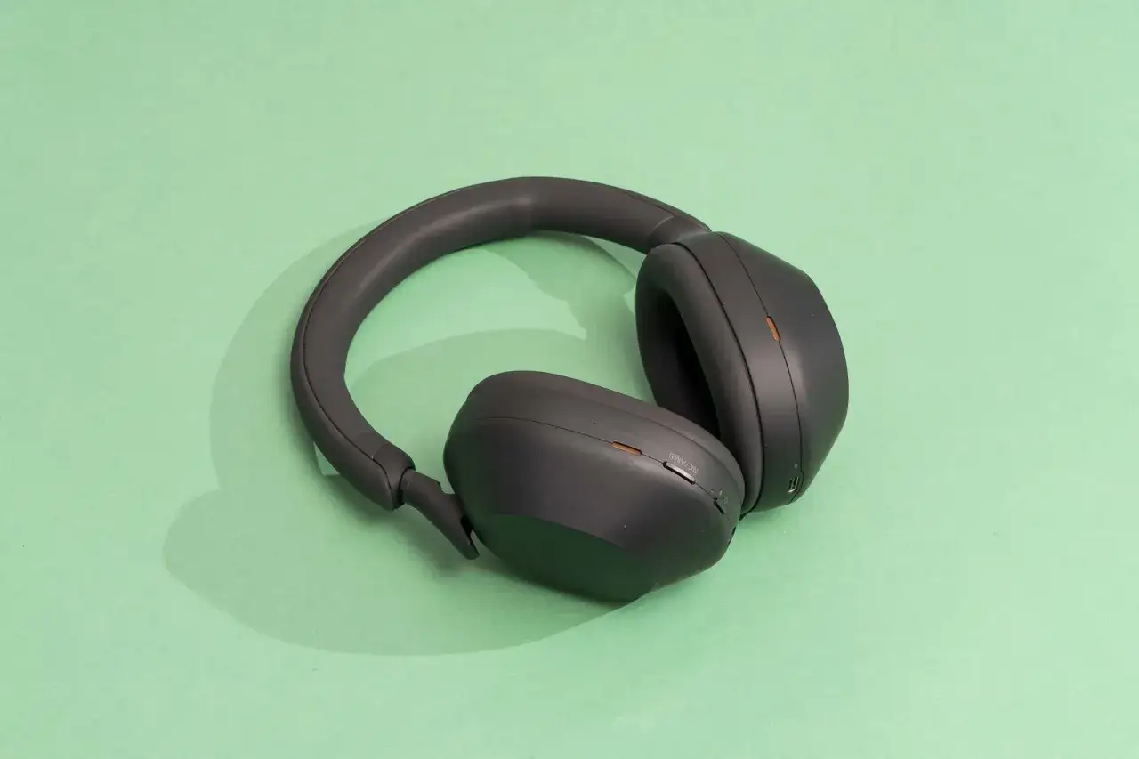 Casque circum-aural noir, posé sur fond vert menthe. Idéal pour une immersion sonore totale.