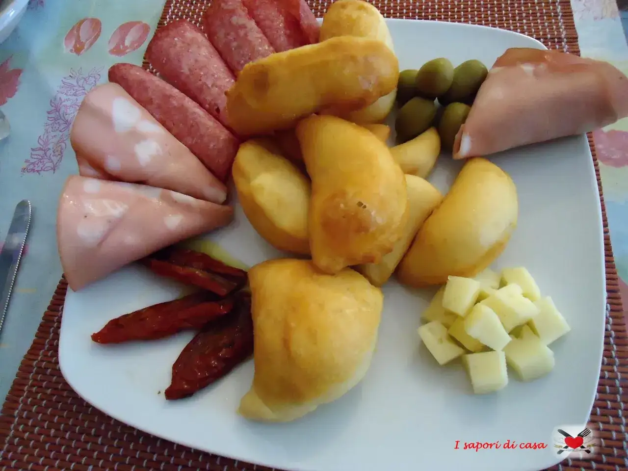 Piatto con salumi, formaggio a cubetti, olive, pomodori secchi e tanti gnocco fritto Ferrara dorati e fragranti.