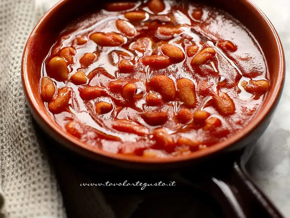 Fagioli all'uccelletto in ciotola di terracotta, un classico della cucina italiana. Perfetti per scoprire cosa abbinare ai fagioli all'uccelletto per un pasto completo.