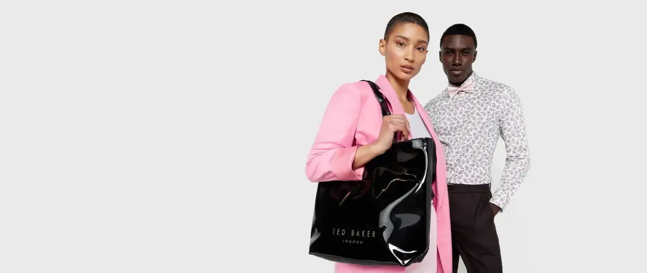 Elegancka kobieta z torbą Ted Baker London i mężczyzna w koszuli z wzorem. Ted Baker to brytyjska marka odzieżowa.