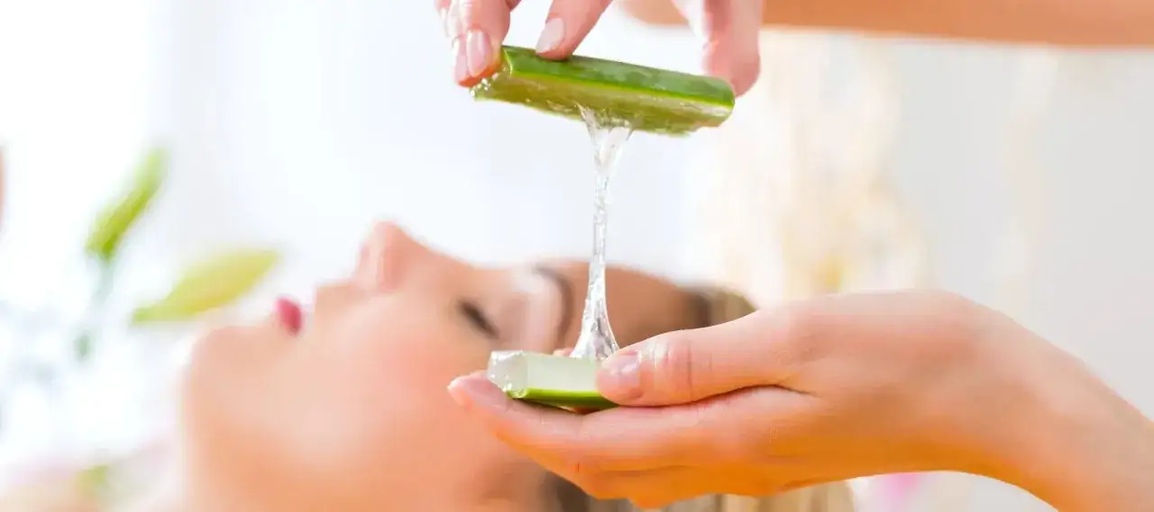 Delikatny żel z aloesu spływa z liścia na dłoń, przygotowany do pielęgnacji twarzy.