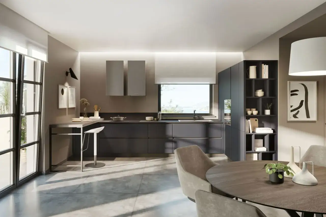 Cucina moderna con isola, mobili grigio antracite e dettagli in vari **tipi di grigio**. Tavolo rotondo e sedie in tessuto completano l'ambiente.