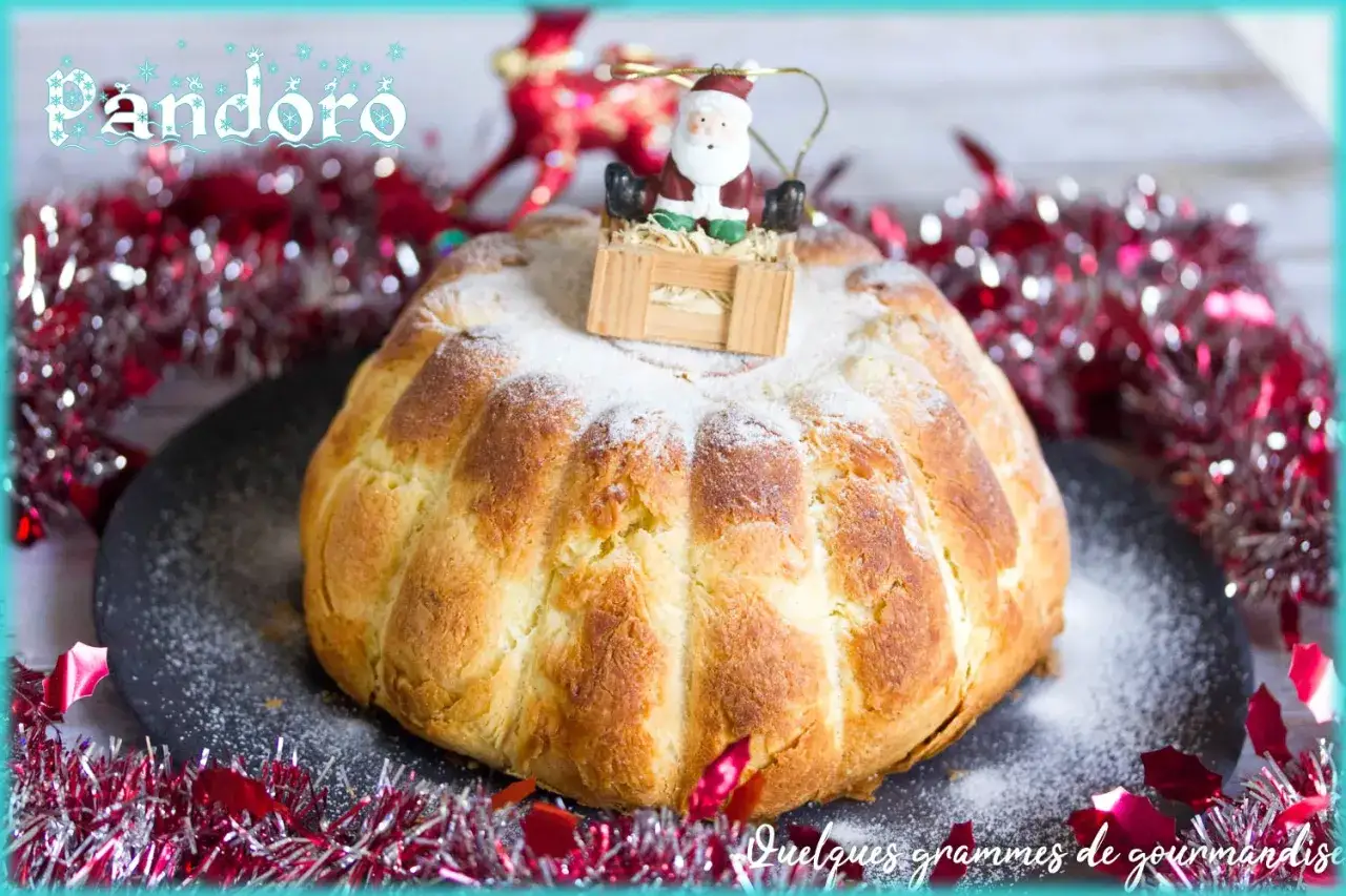 La brioche italienne Pandoro, saupoudrée de sucre glace, est décorée d'un petit Père Noël. Elle est entourée de guirlandes rouges festives.