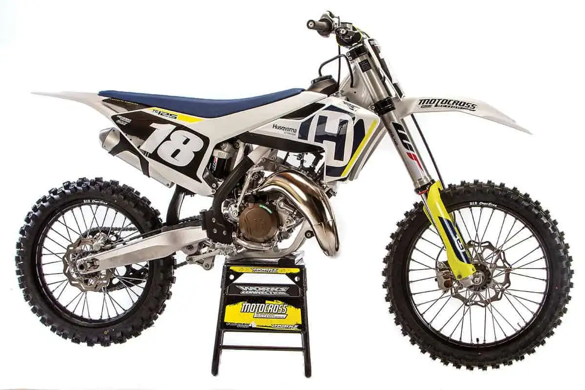 Motocykl Husqvarna TC125 z numerem 18, gotowy do wyścigów motocrossowych.