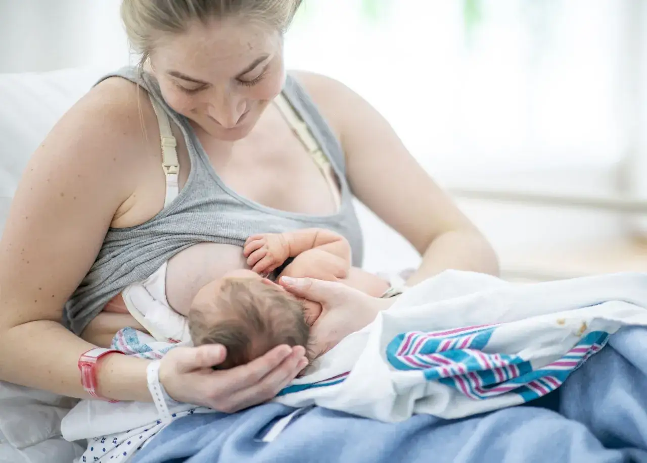 Eine Mutter stillt ihr Neugeborenes liebevoll. Dies ist ein nat&uuml;rlicher Weg, die milchproduktion anzuregen und eine starke Bindung aufzubauen.
