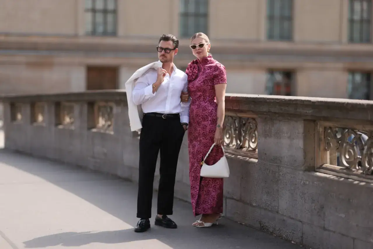 Elegancka para, która wie, jak się ubrać do teatru. On w białej koszuli i czarnych spodniach, ona w różowej sukni z wzorem róż.