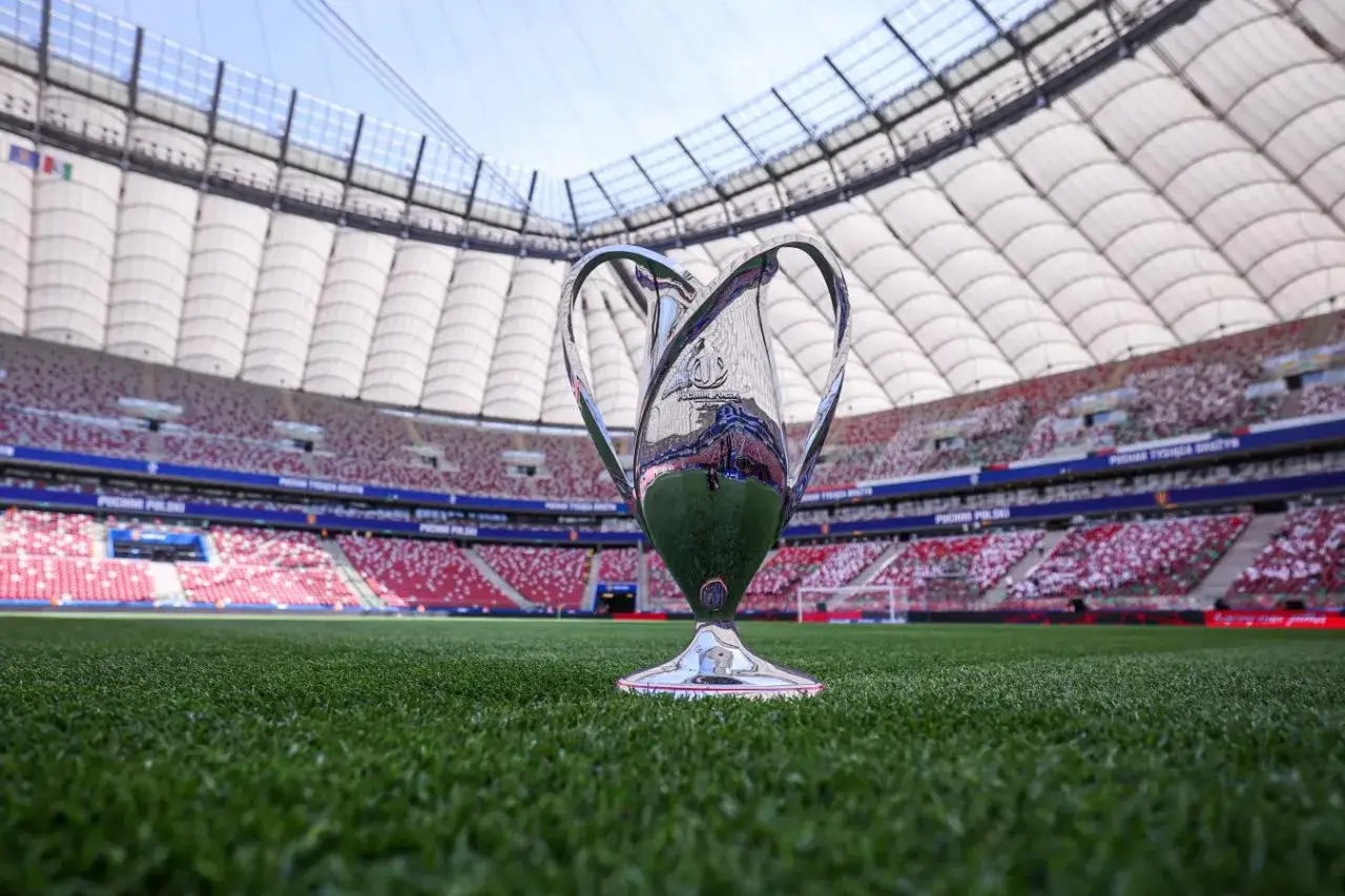 Błyszczący puchar na murawie stadionu, symbol marzeń o zwycięstwie w **pucharze Polski**.