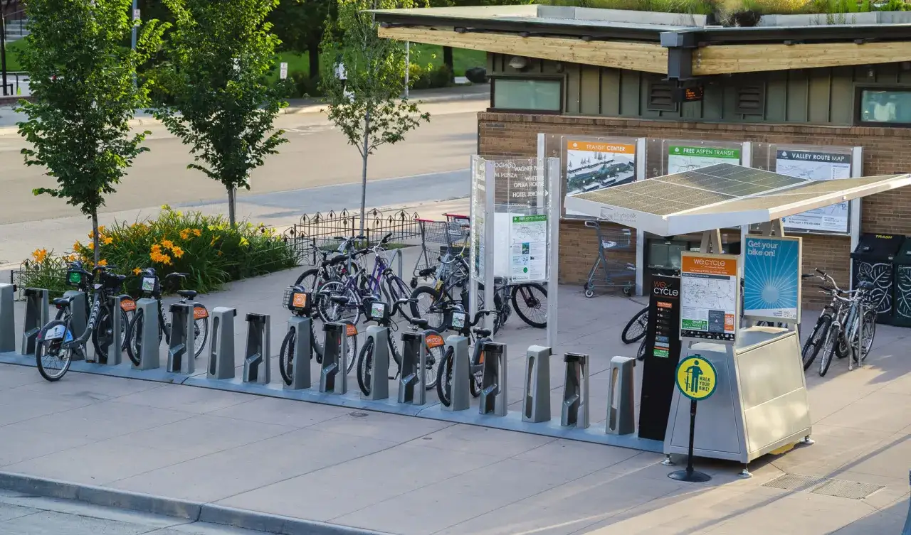 Des vélos en libre-service attendent d'être loués, prêts à recharger vélo sur borne auto.
