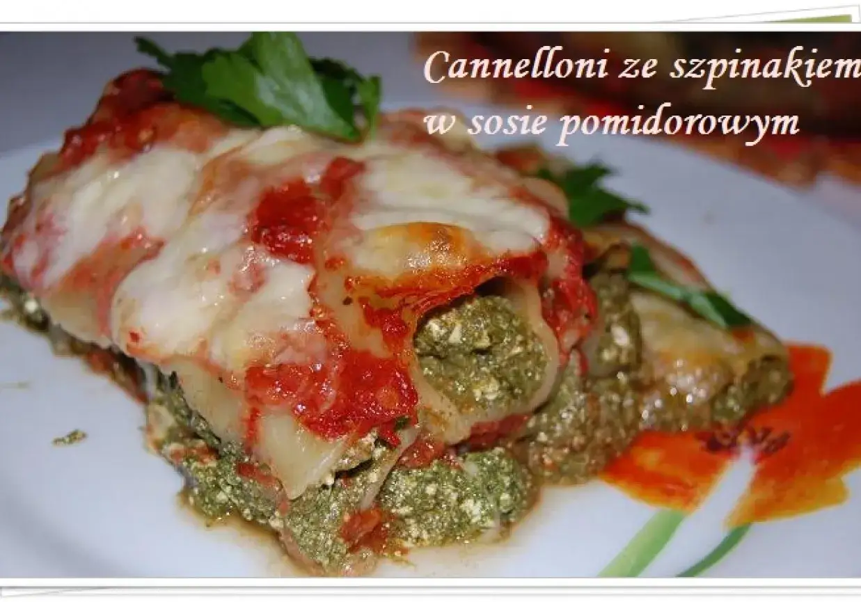 Pyszne cannelloni ze szpinakiem w sosie pomidorowym, zapieczone pod serem. Danie wygląda apetycznie i zachęca do spróbowania.