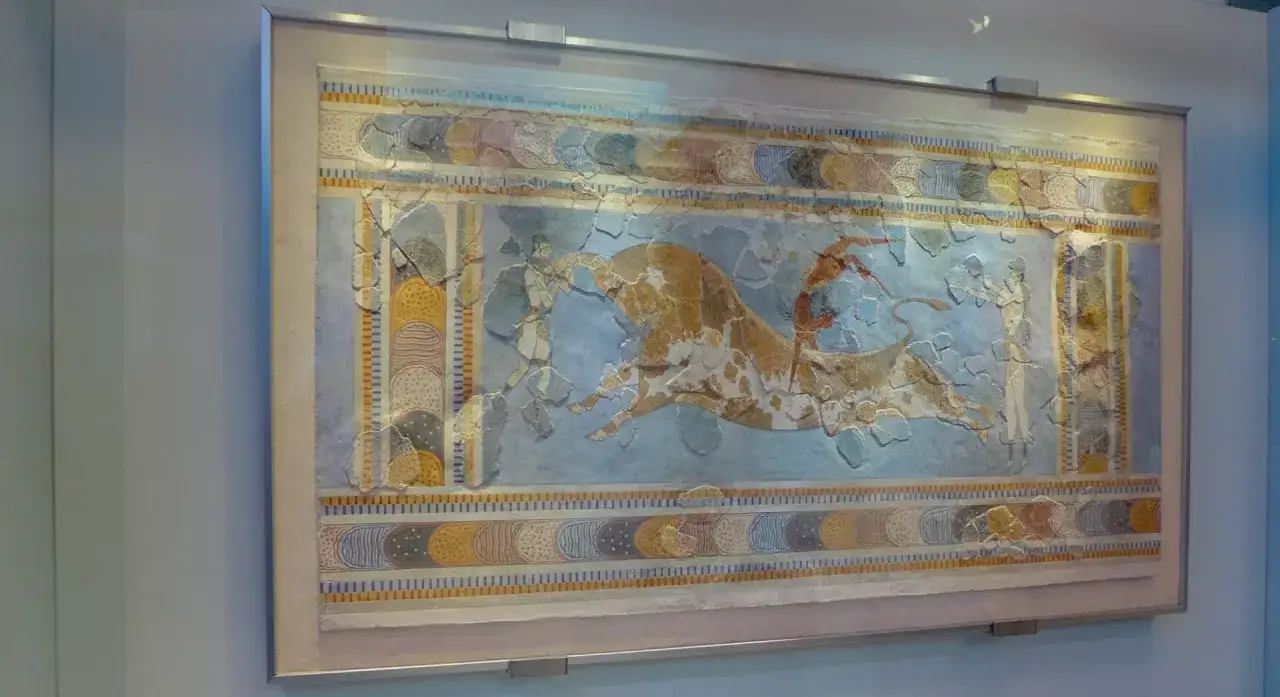 Fresk z muzeum archeologicznego w Heraklionie: akrobaci skaczą przez byka.