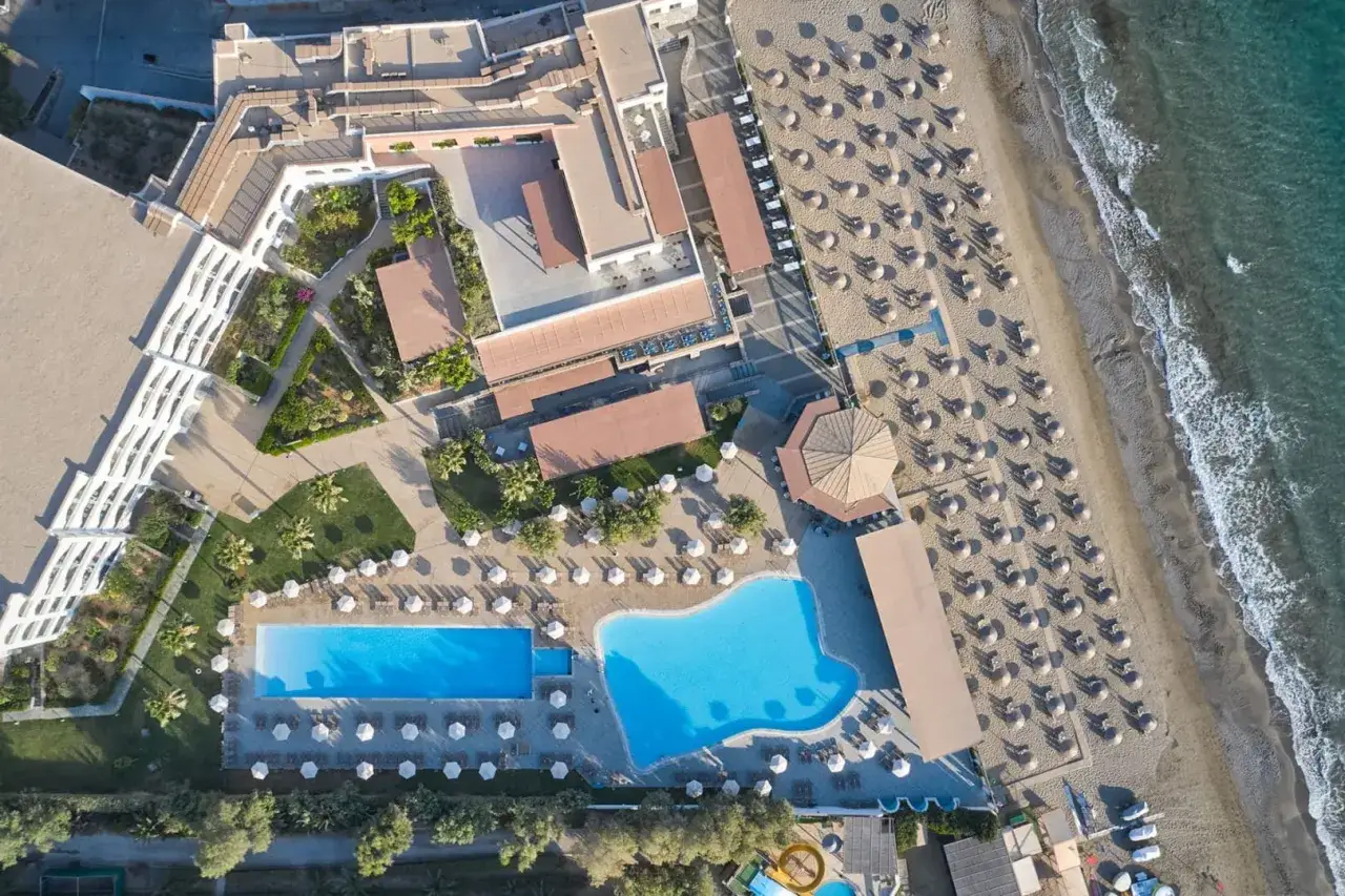 Atlantica Akti Zeus: opinie o hotelu z basenami i plażą. Widok z lotu ptaka na kompleks hotelowy z basenami, leżakami i morzem.
