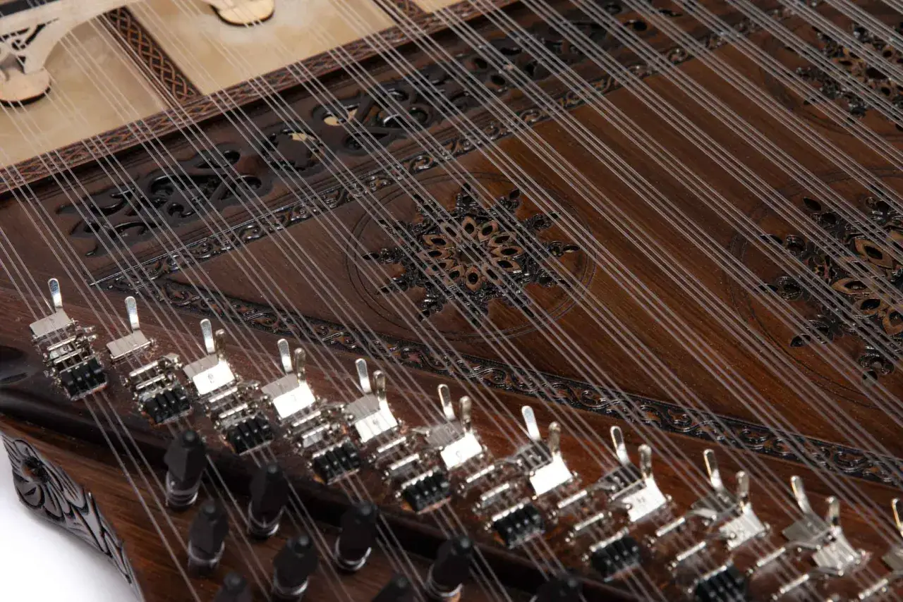 Le kanun, un instrument &agrave; cordes pinc&eacute;es aux multiples cordes fines tendues sur un bois sombre orn&eacute;, pr&ecirc;t &agrave; faire vibrer sa musique.