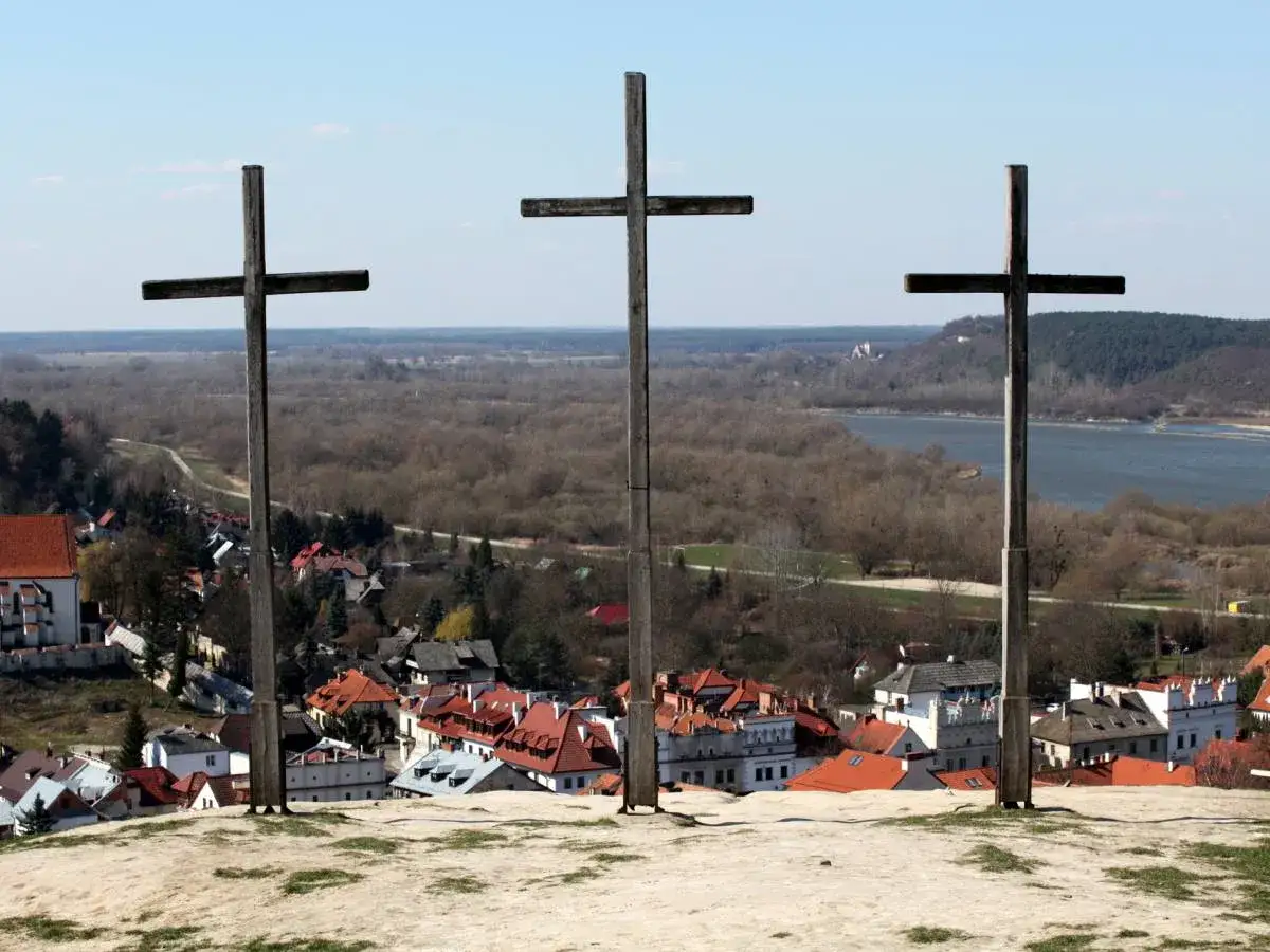 Trzy drewniane krzyże g&oacute;rują nad Kazimierzem Dolnym, oferując widok na miasteczko i Wisłę.