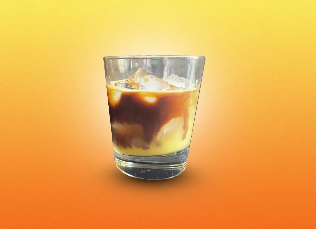 Orzeźwiający napój: espresso z sokiem pomarańczowym i lodem w szklance.