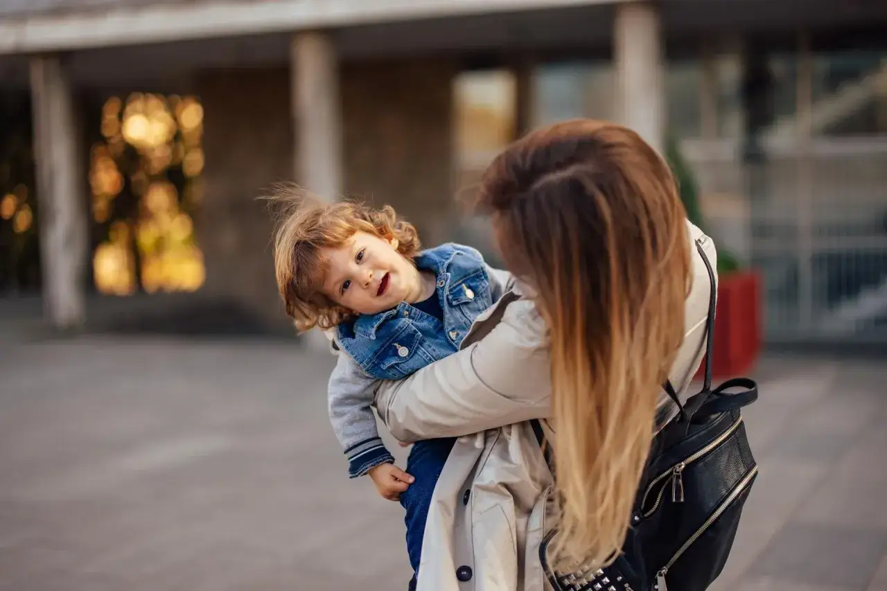 Mama tuli 2-latka, który czuje lęk separacyjny, przytula go mocno. Dziecko wtula się w nią, szukając pocieszenia.