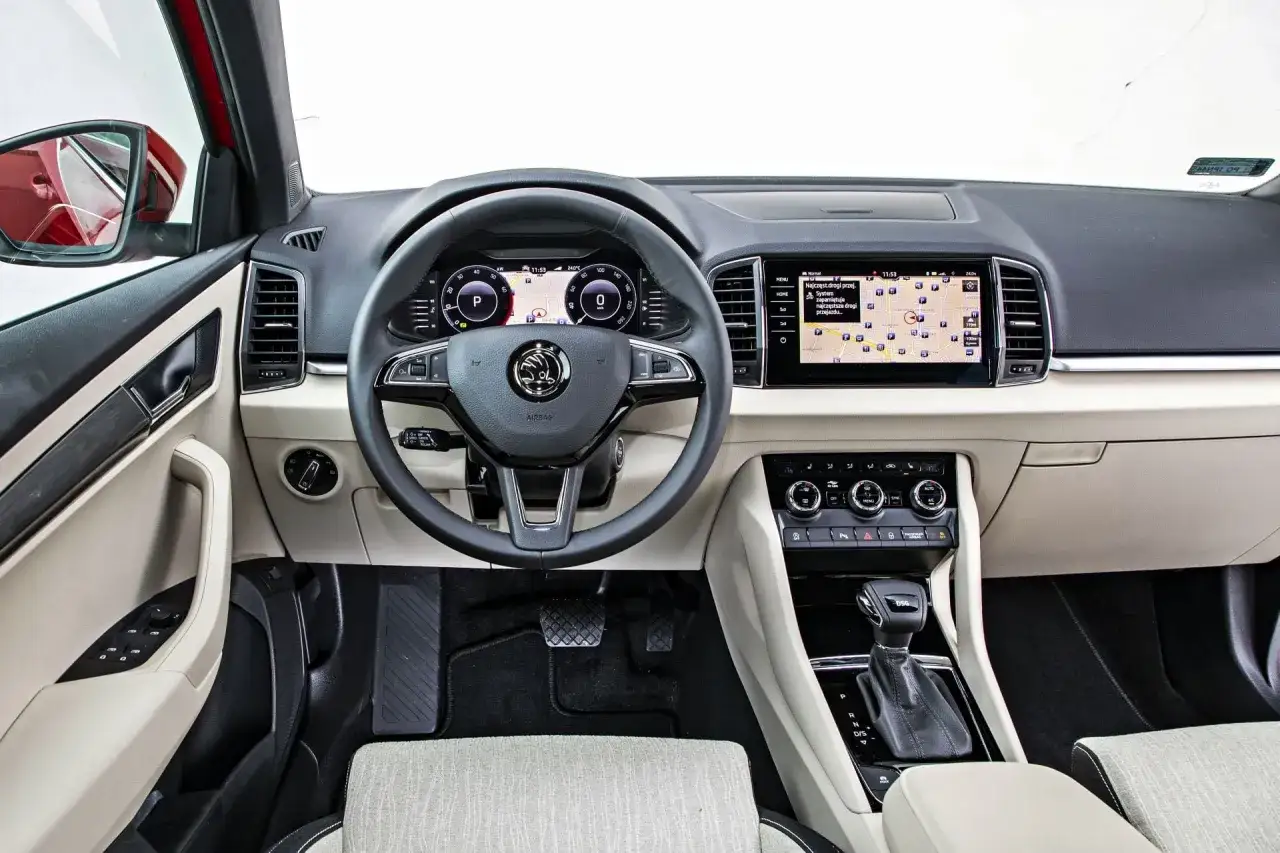 Wnętrze Skoda Karoq z ekranem nawigacji i cyfrowymi zegarami. Kierownica wielofunkcyjna, automatyczna skrzynia biegów DSG.