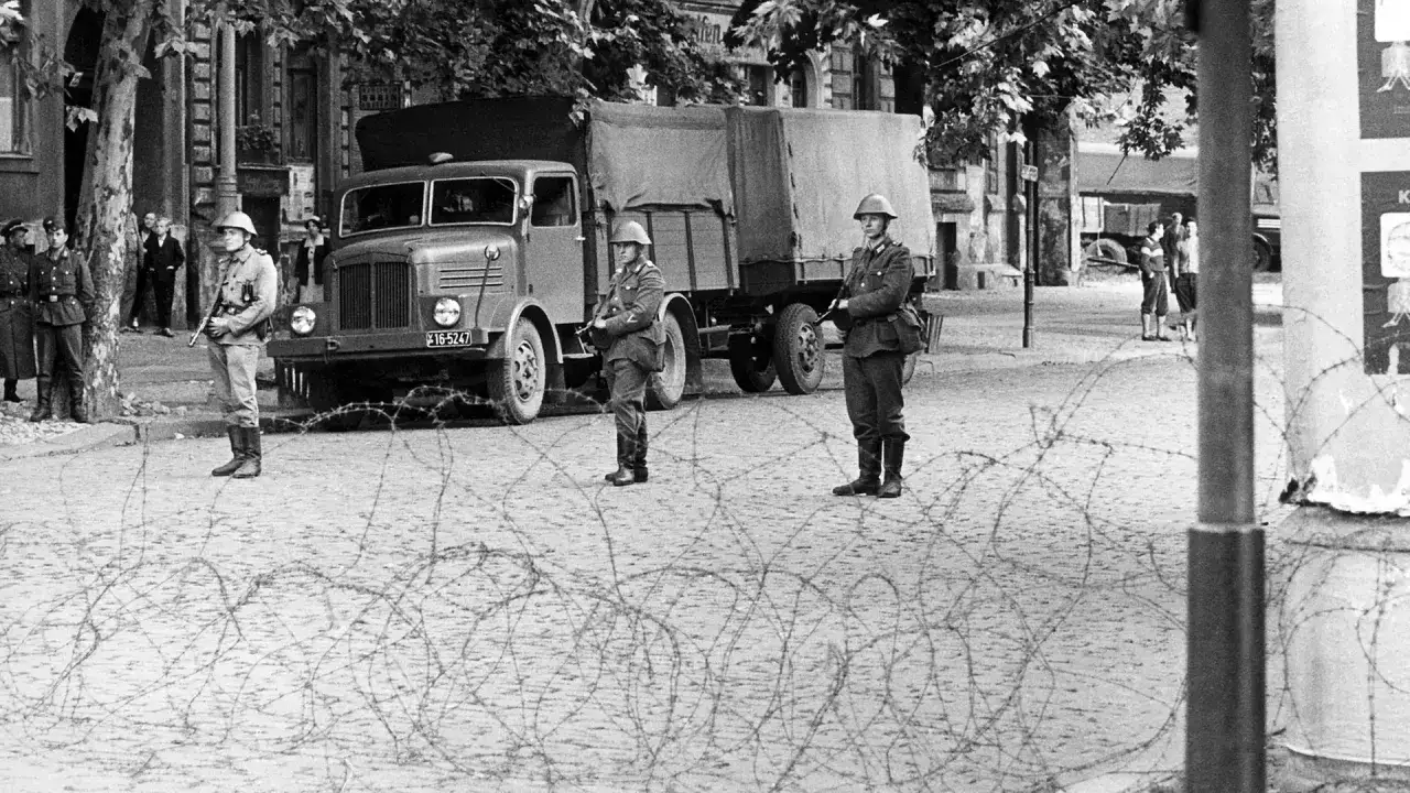Soldaten bewachen die Grenze. Sie sind Teil derer, wer die Berliner Mauer gebaut hat, um die Stadt zu teilen.