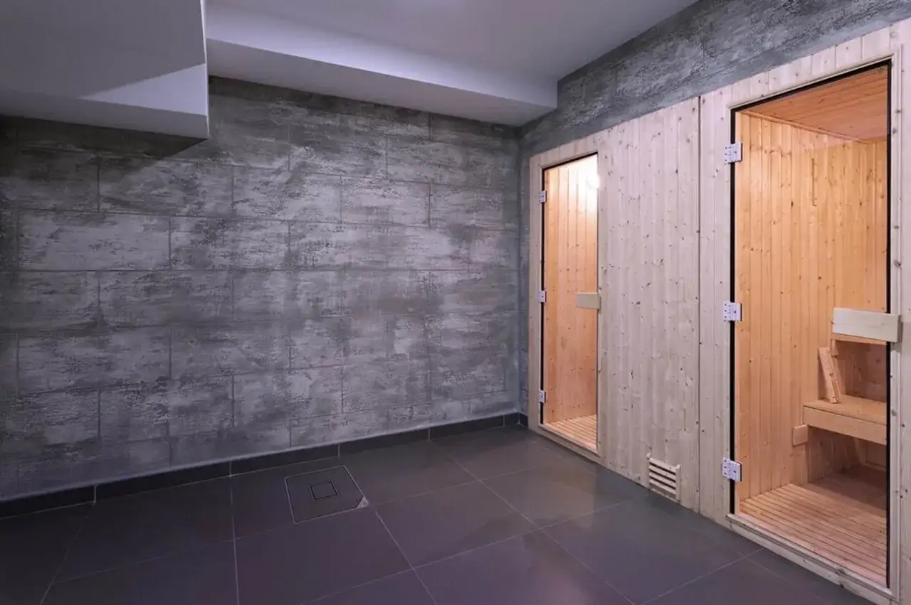 Nowoczesny pomysł na ściany w piwnicy: beton architektoniczny i drewno w dwóch saunach.