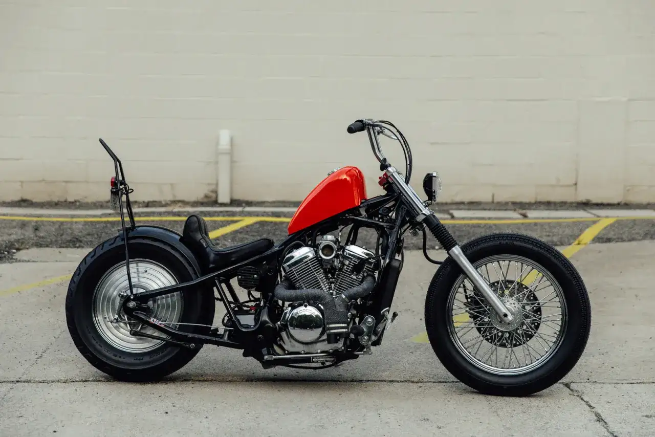Customowy chopper z czerwoną ramą, czarnym siedzeniem i błotnikami. Dane techniczne Honda Shadow 600.