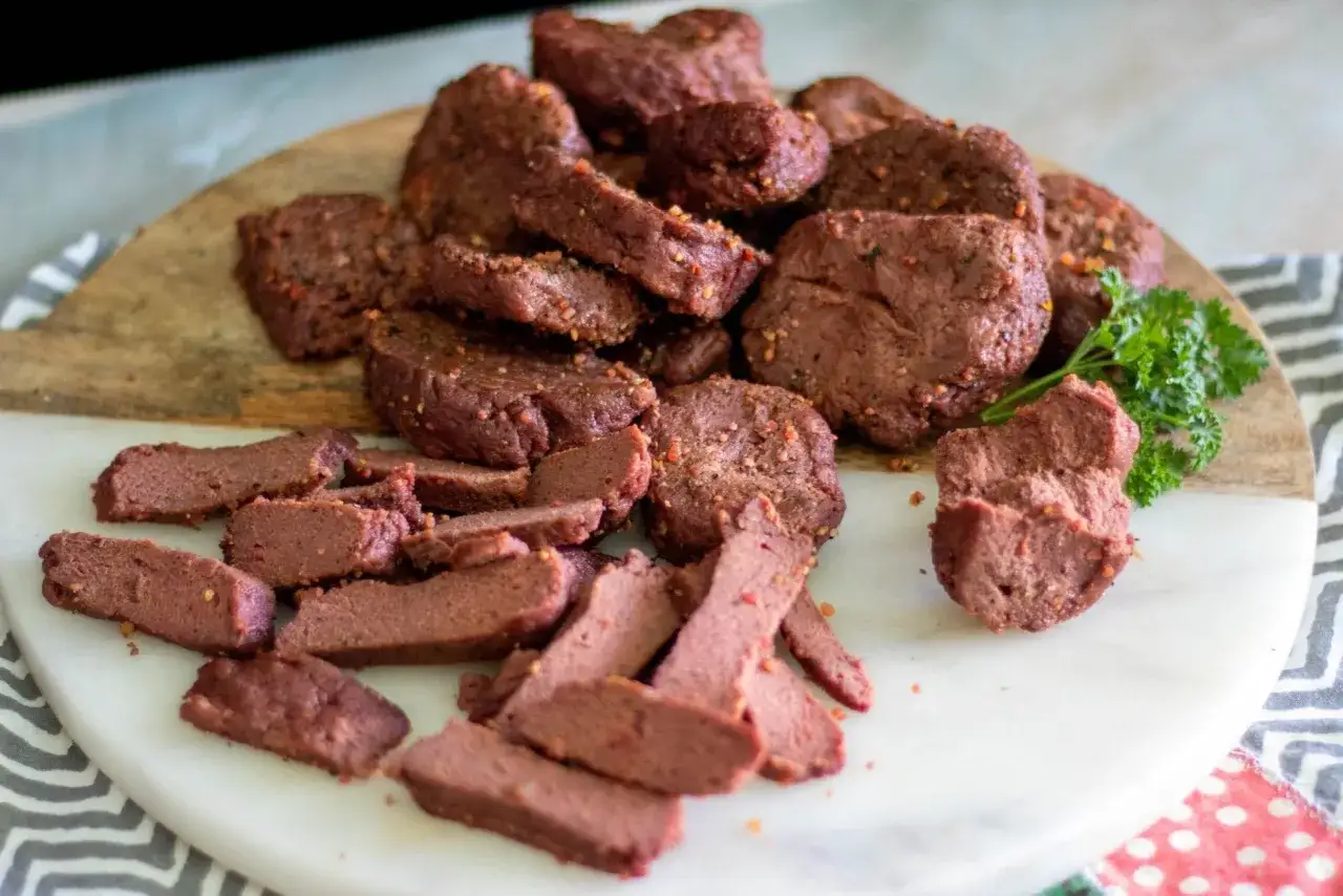 Montón de trozos de seitan casero, listos para deliciosas recetas. Algunas piezas están cortadas en tiras finas, otras en trozos más gruesos.