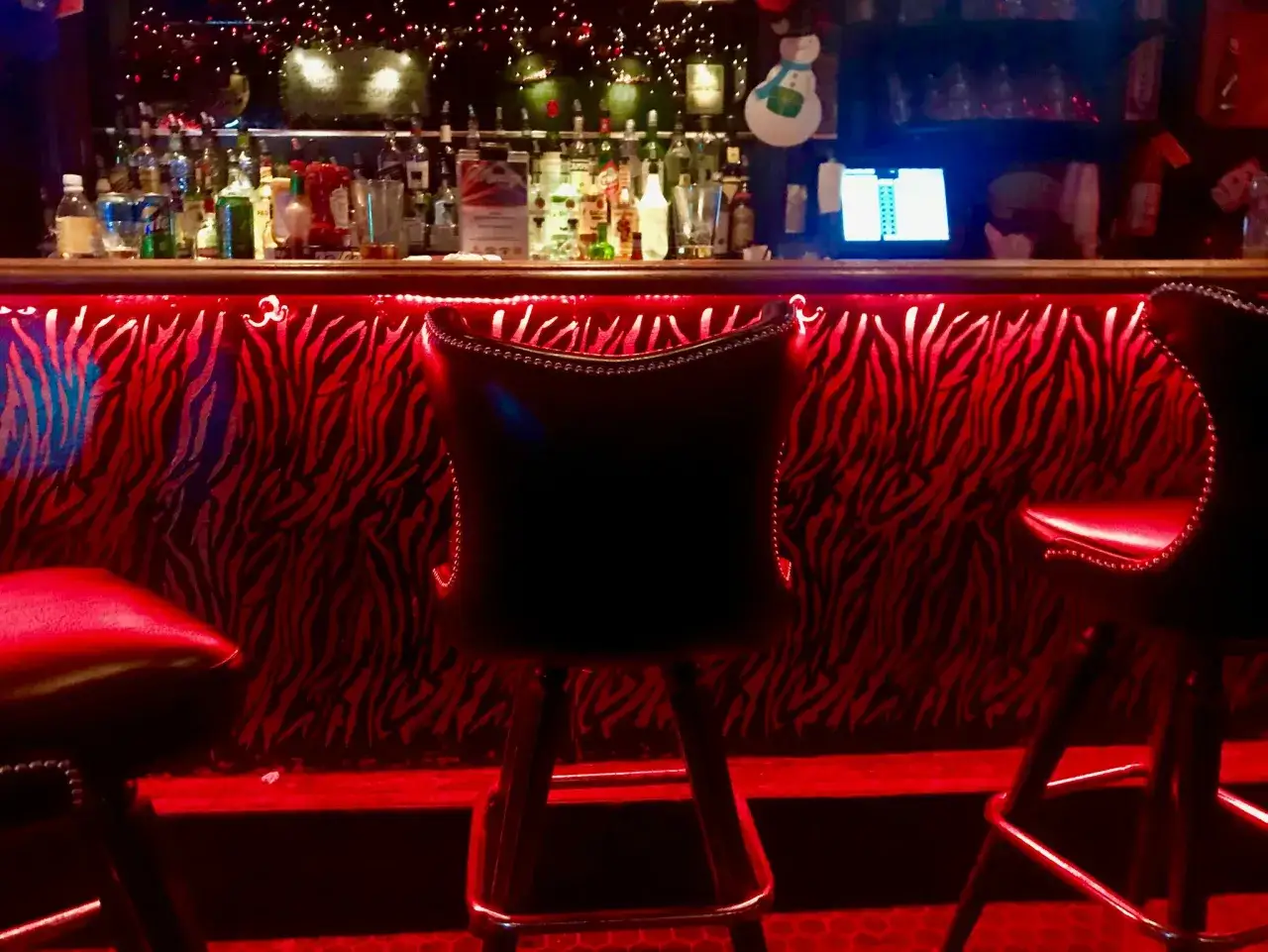 Ambiance tamisée d'un bar, sièges rouges et motif zèbre. Parfait pour un speed dating à Paris.