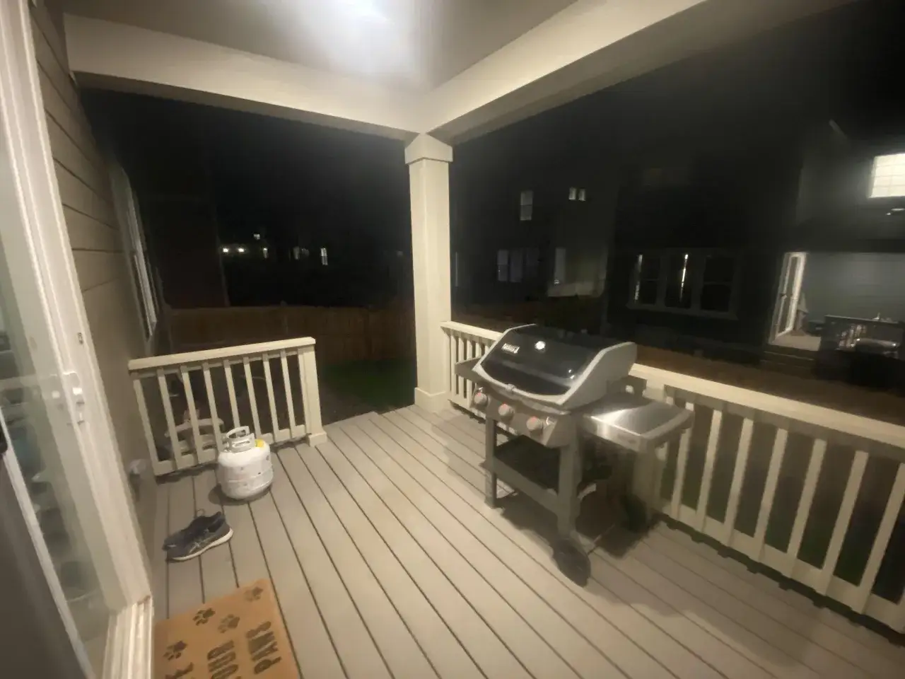 En gasolgrill under taket på altanen, redo för sommarens grillkvällar.