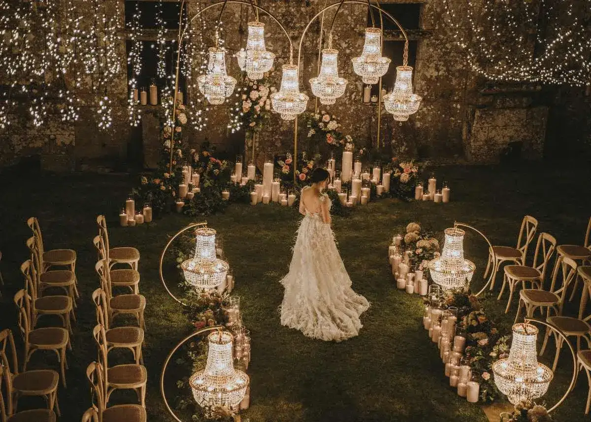Novia en un jardín iluminado por velas y candelabros, evocando la magia de las bodas ibicencas.