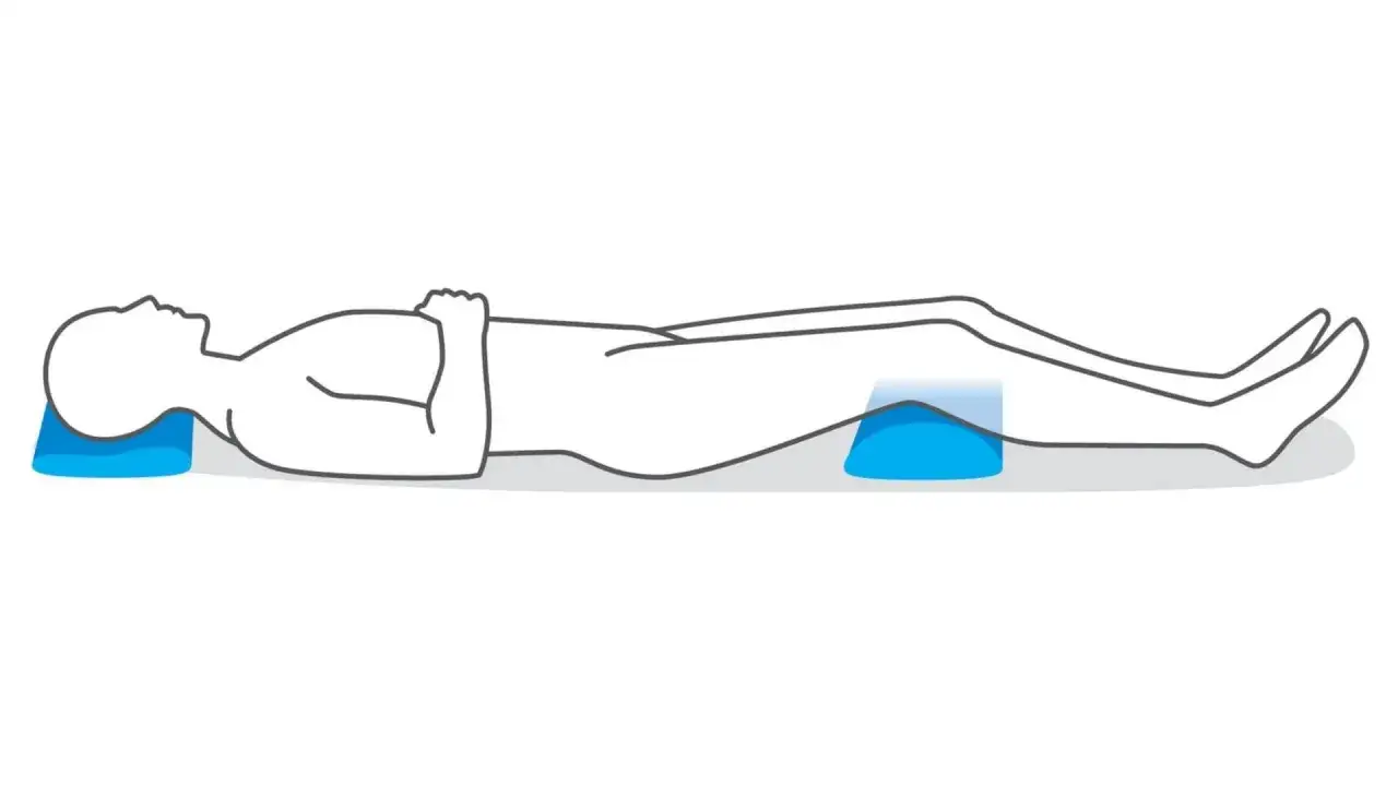Silhouette d'une personne allong&eacute;e, t&ecirc;te et genoux sur des coussins bleus, pour soulager la discopathie et la douleur la nuit.