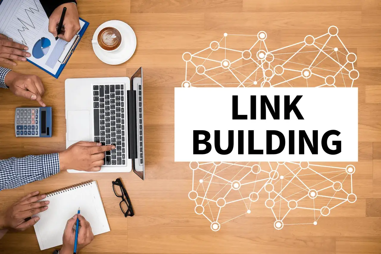 Zesp&oacute;ł pracuje nad strategią link buildingu. Na stole laptop, kalkulator, notatnik i kawa.