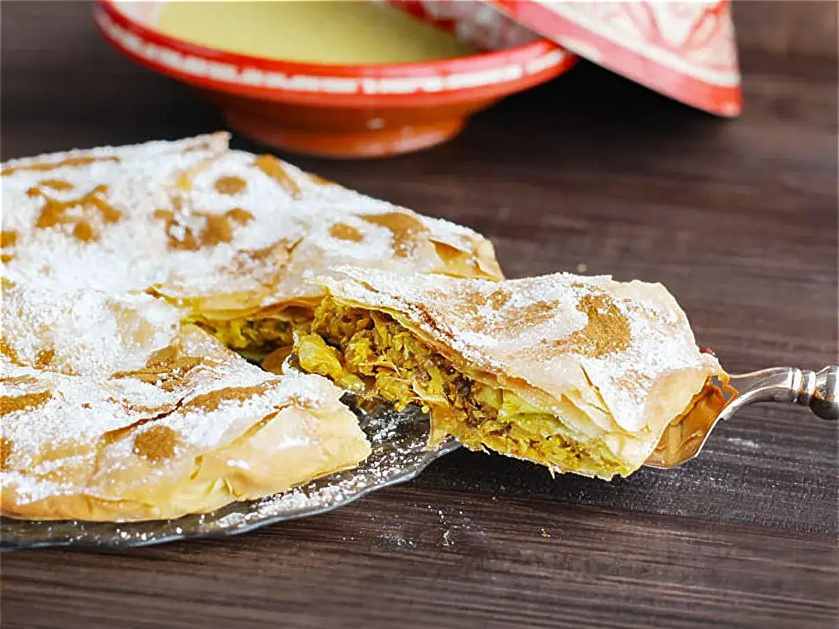 Deliciosa pastela marroqui, crujiente por fuera y rellena de un sabroso guiso, espolvoreada con azúcar glas y canela.