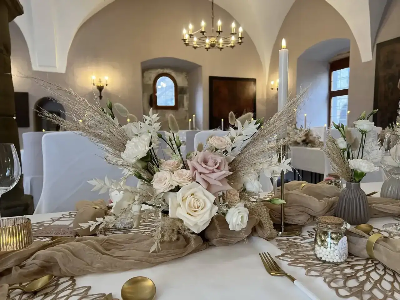 Festlich gedeckter Tisch mit Blumenarrangement, Kerzen und goldenen Akzenten. Ein Zeichen f&uuml;r den 14. Hochzeitstag Bedeutung.