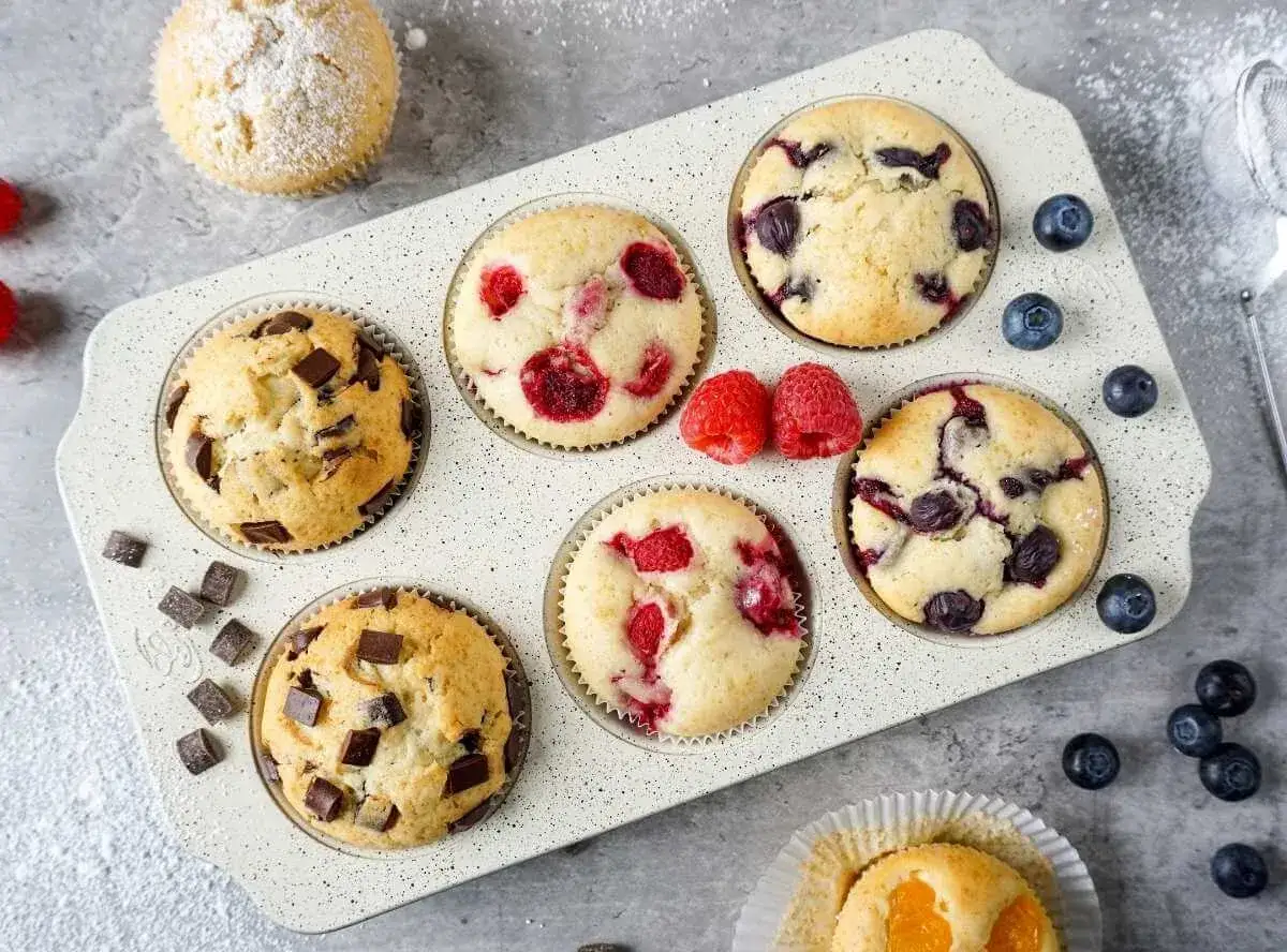 Schokoladen-, Himbeer- und Blaubeermuffins in einer Form. Diese sehen aus wie die besten muffin rezepte zum Nachbacken.