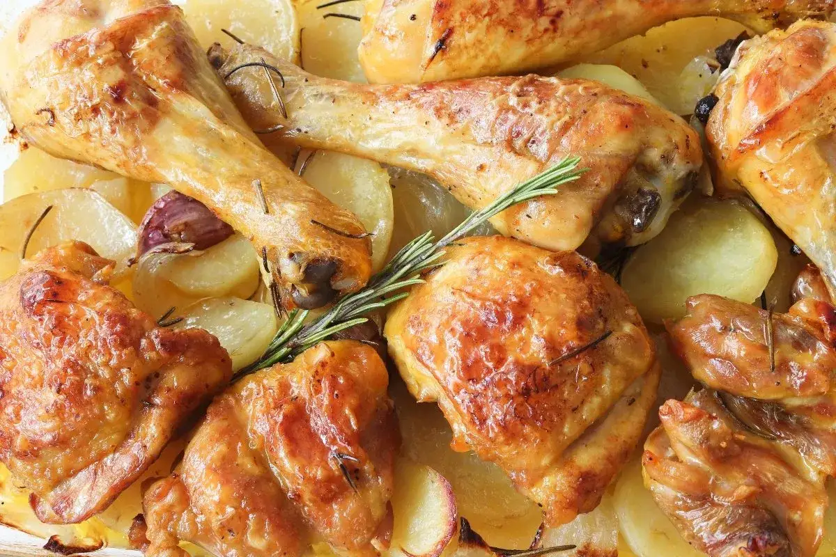 Pollo asado jugoso y dorado sobre patatas asadas con romero y ajo. &iexcl;Un fest&iacute;n para la vista y el paladar!