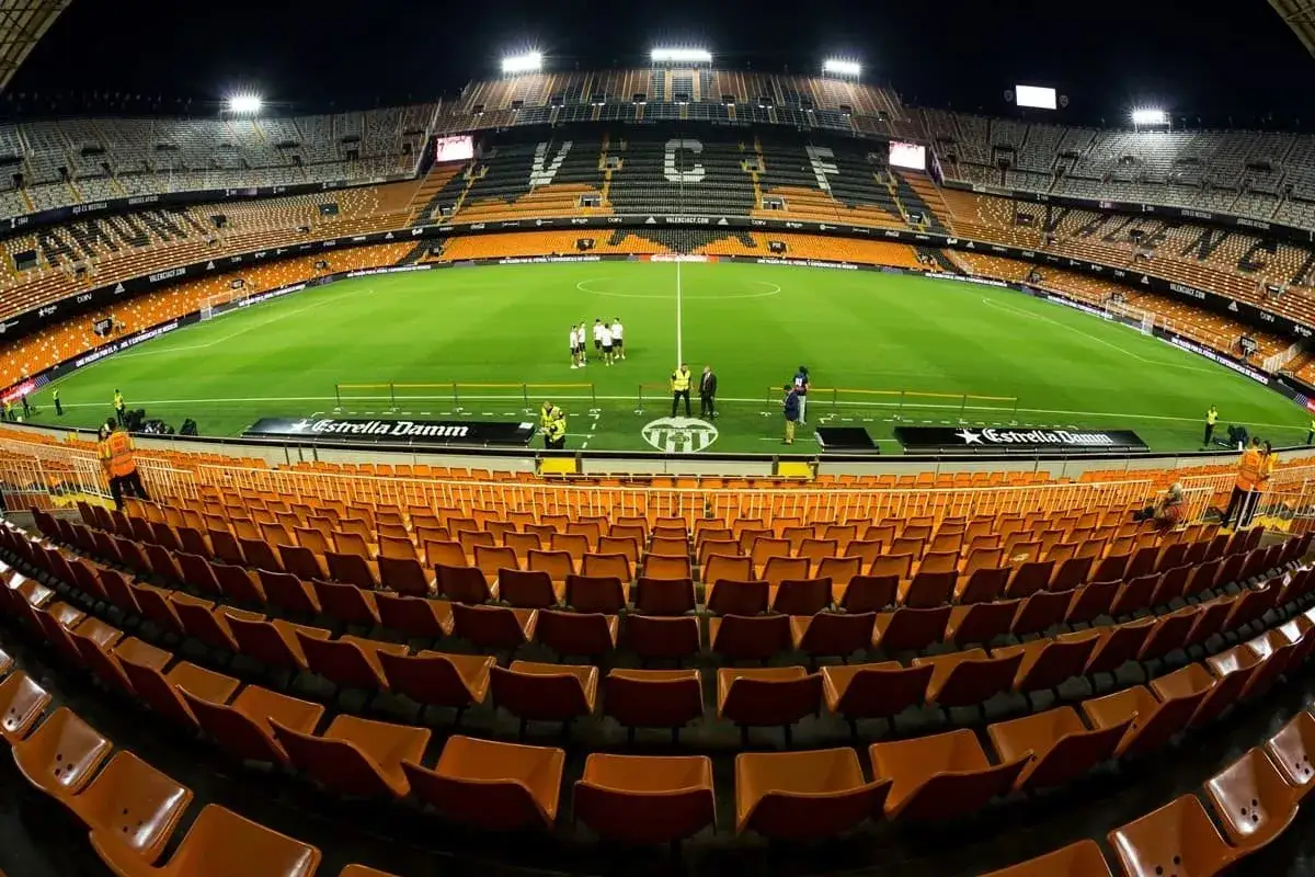 Pusta trybuna stadionu Mestalla przed meczem FC Barcelona – Valencia CF. Pomarańczowe krzesełka czekają na kibiców.