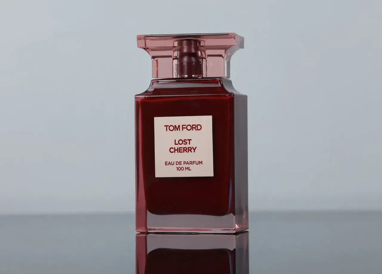 Elegancka butelka perfum Tom Ford Lost Cherry 100 ml w odcieniu głębokiej czerwieni, z różową nakrętką.