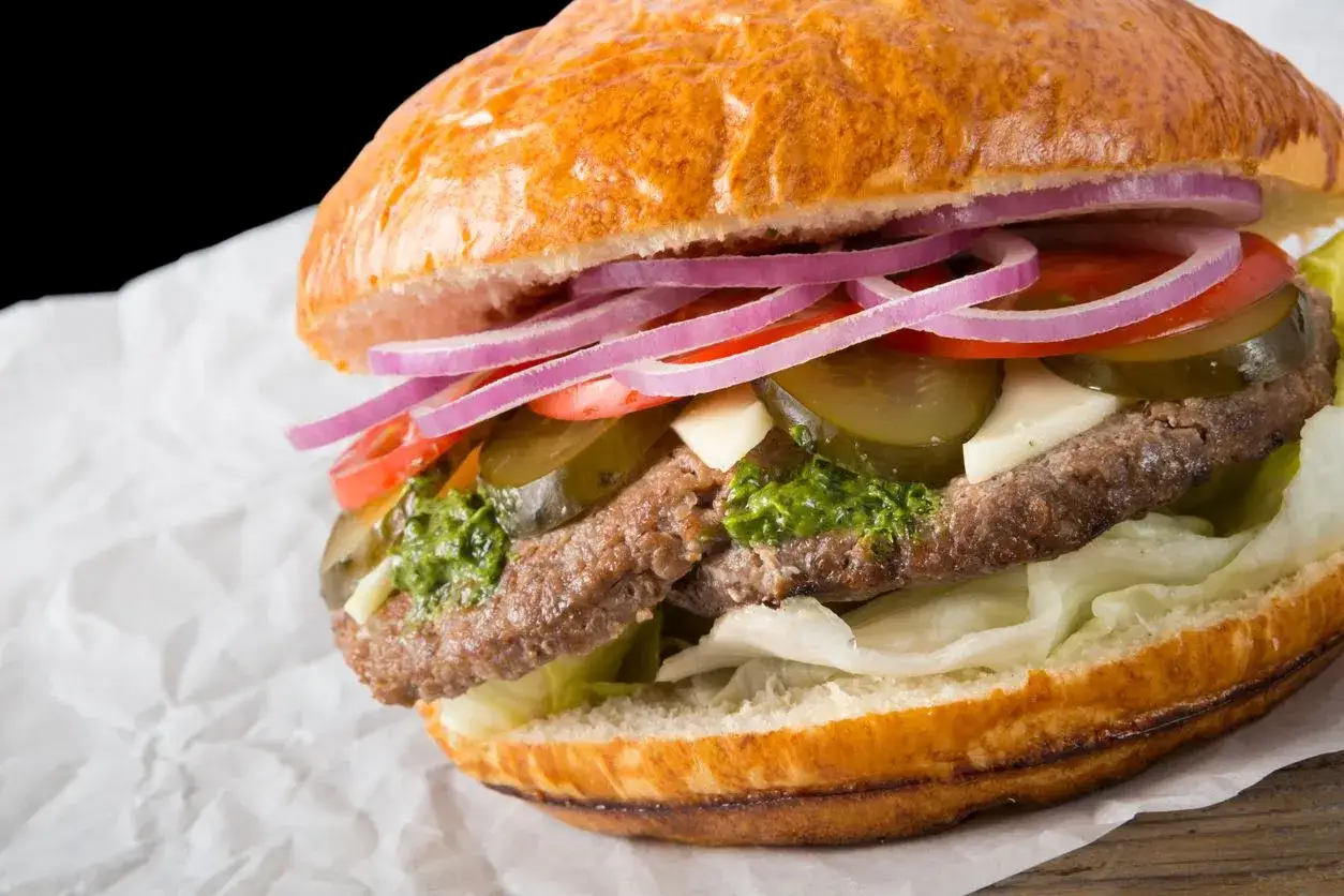 Soczysty burger z wołowiny, sałatą, pomidorem, ogórkiem, cebulą i zielonym sosem. Czy to hamburger czy burger? To zależy od dodatków!