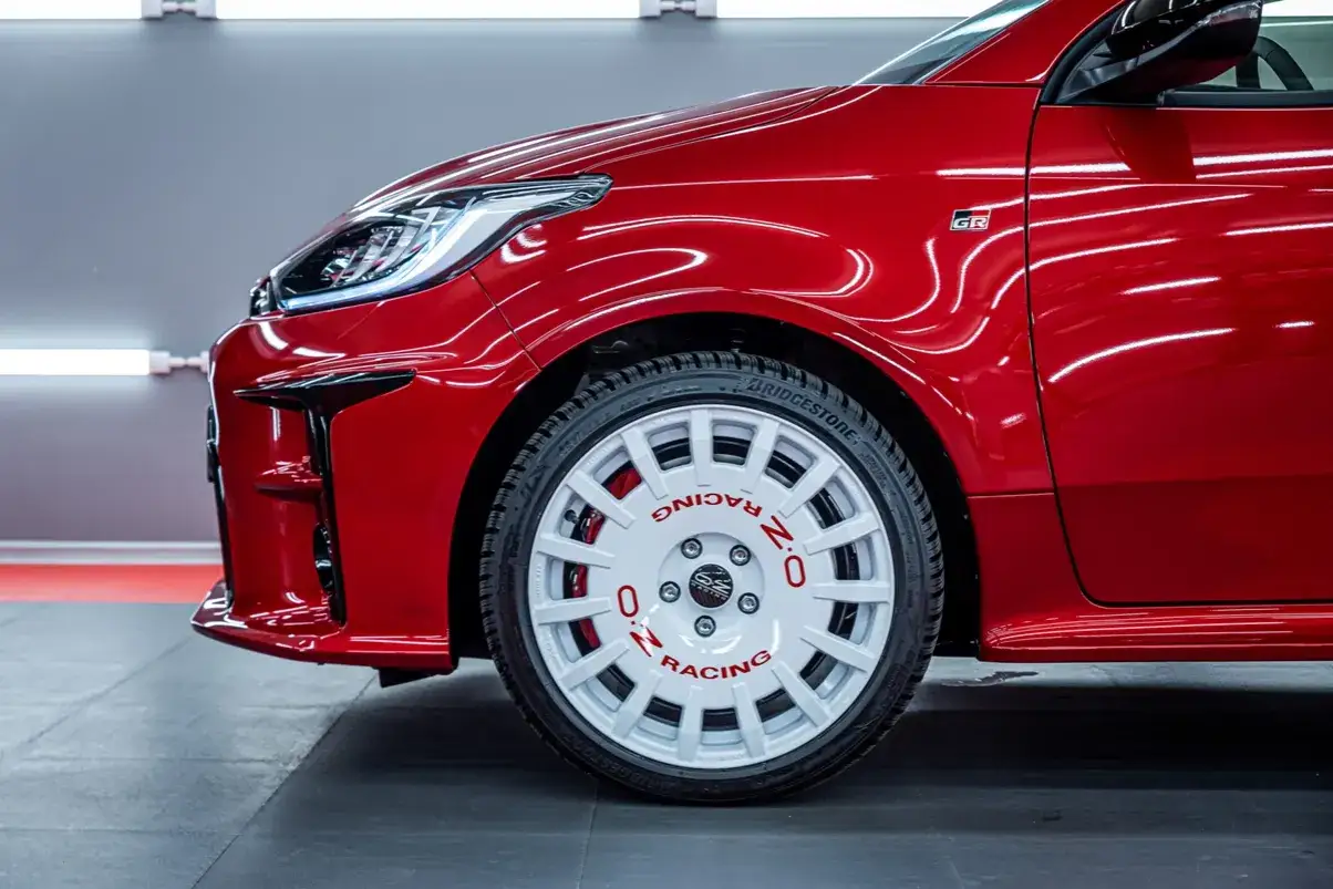Czerwony Toyota Yaris GR Sport z białymi felgami OZ Racing.