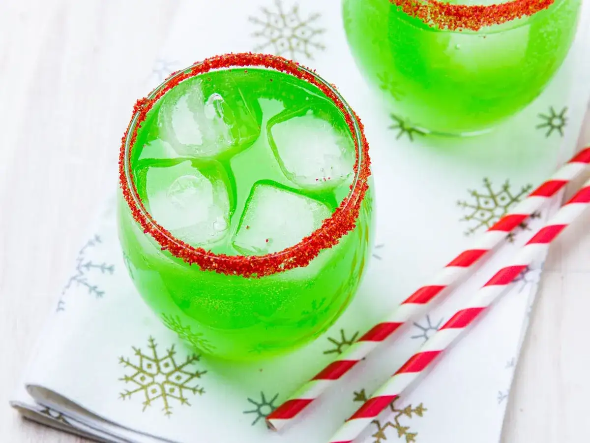 Gr&uuml;ner Grinch Cocktail mit Eis und rotem Rand, perfekt f&uuml;r das n&auml;chste Rezept.
