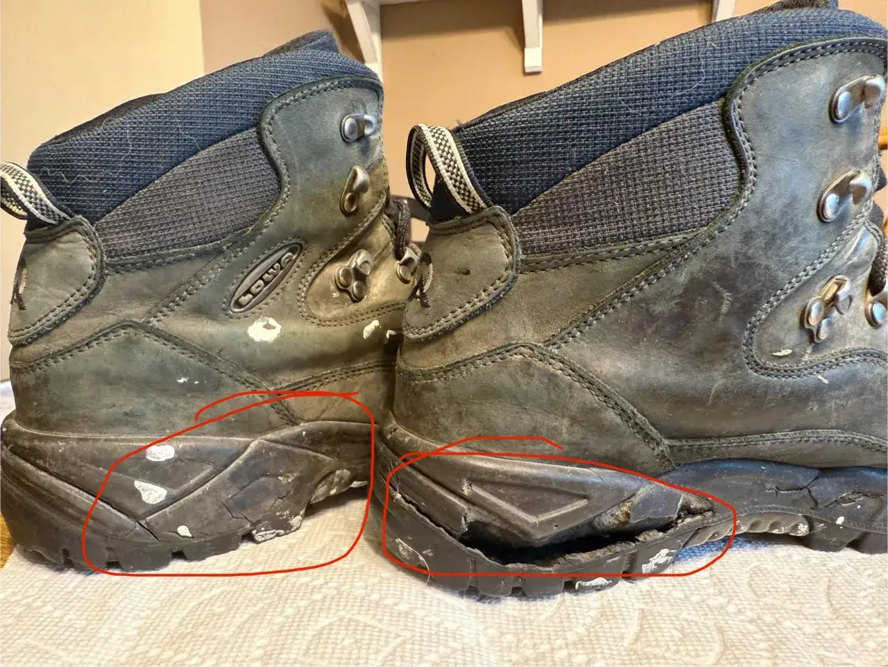 These worn hiking boots show why shoes fall apart when not worn: the soles are cracked and separating, revealing the inner materials.