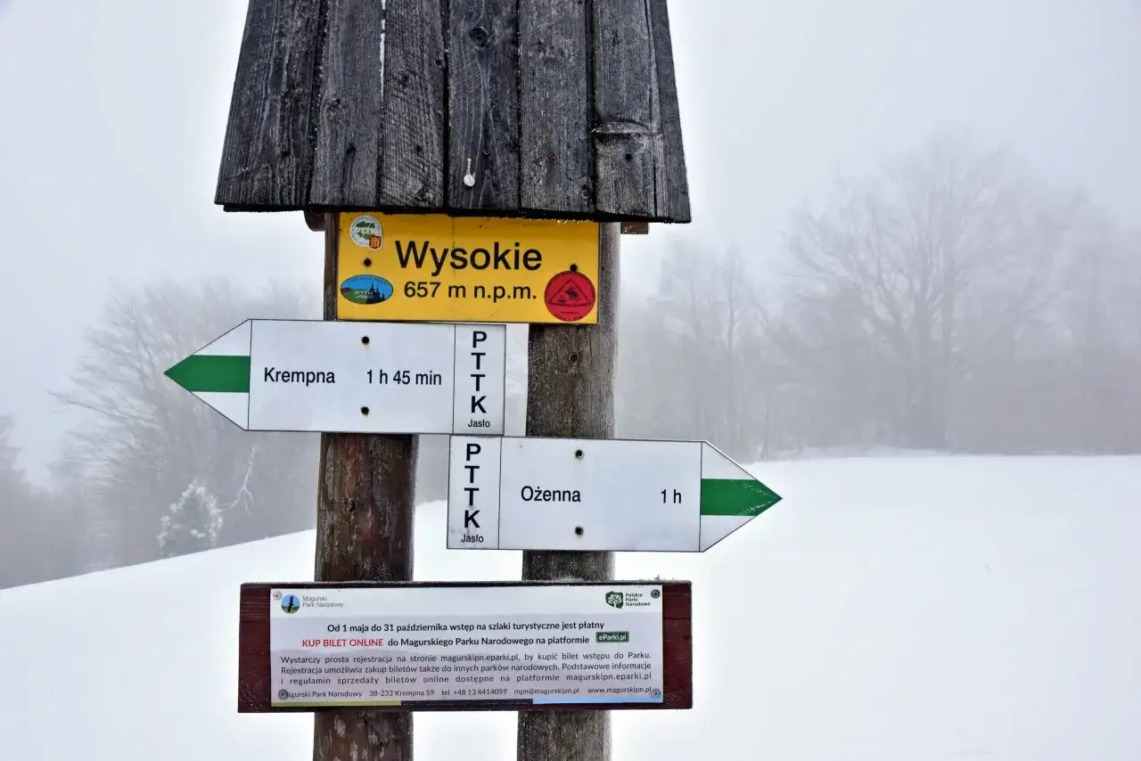 Szlak w Magurskim Parku Narodowym. Znak wskazuje drogę na Wysokie, najwyższy szczyt, 657 m n.p.m.